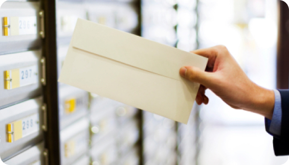 A hand placing mail in a mail slot