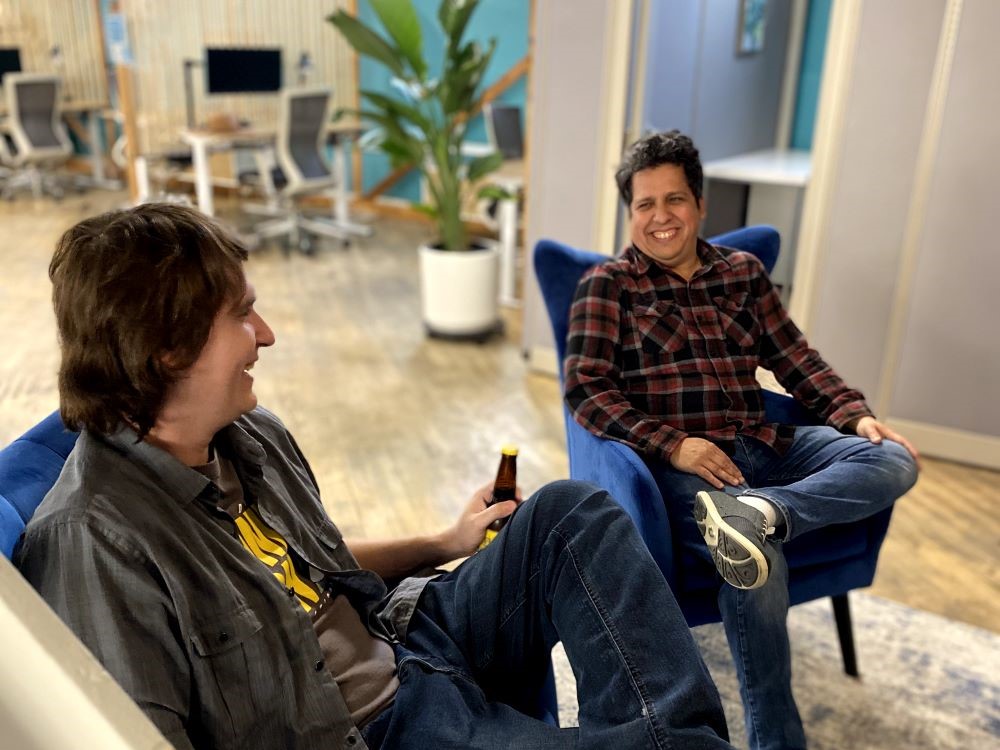 Two coworking members sitting in the lounge area sharing a drink