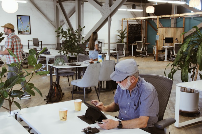 Man sitting at a desk in Cowork And Connect, working on a laptop.