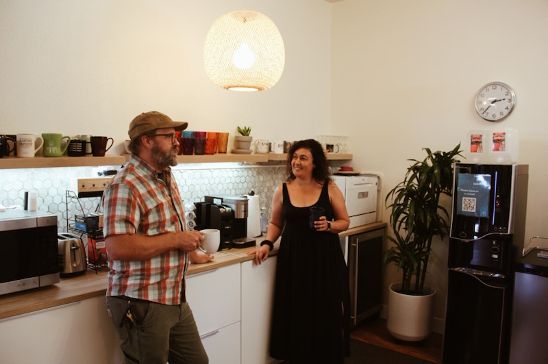 Two coworking members sitting in the lounge area sharing a drink