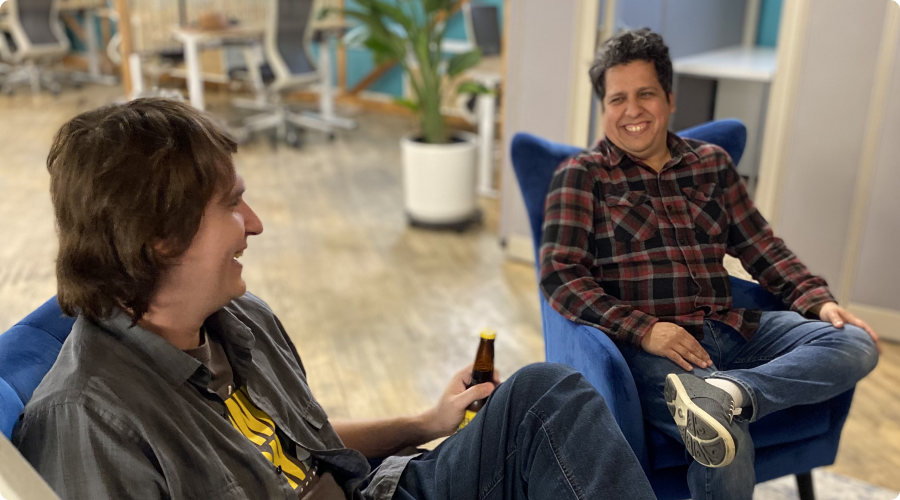 Two men sharing drinks in the lounge area of Cowork + Connect